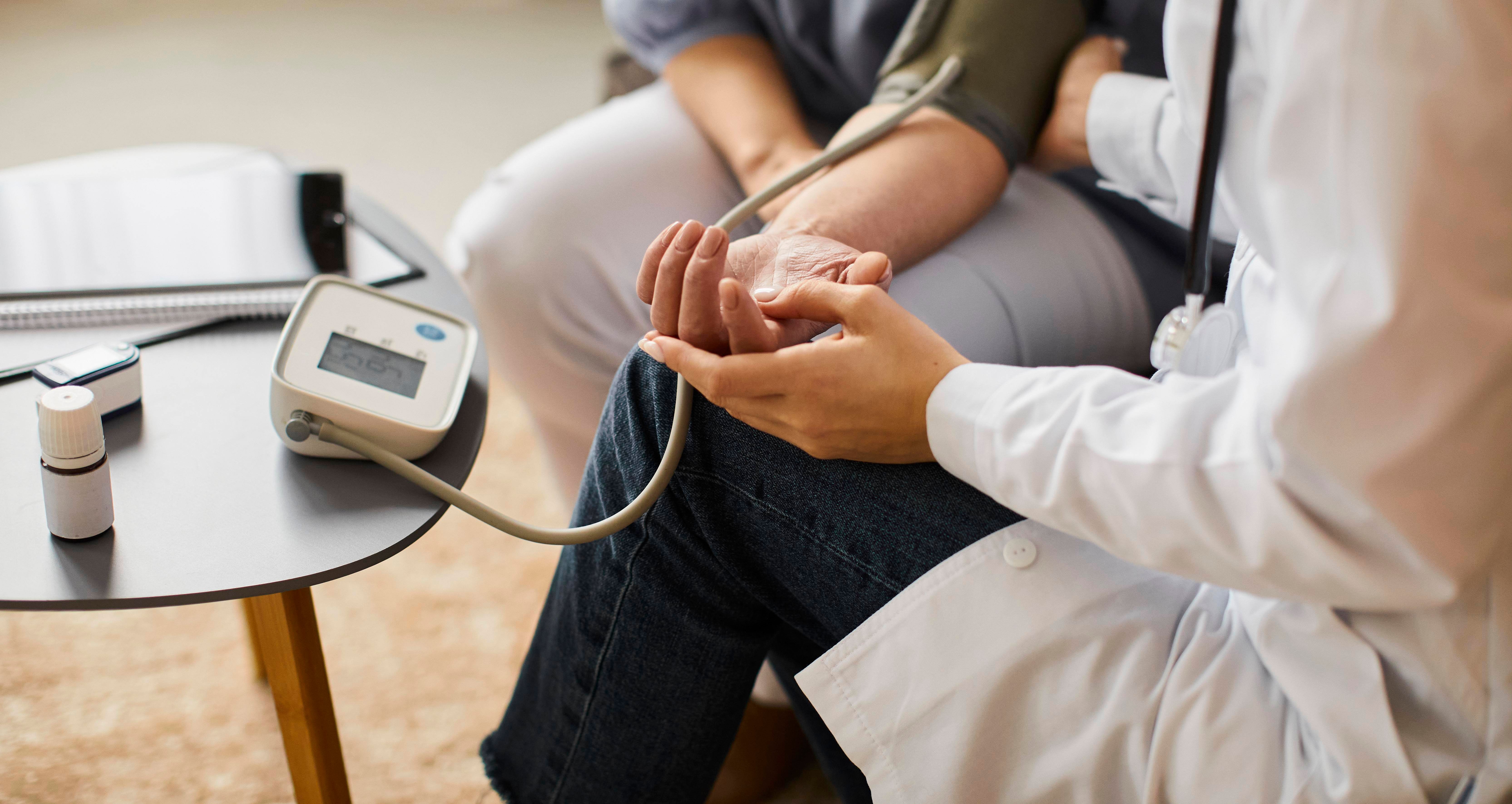 high-angle-covid-recovery-center-female-doctor-checking-elder-patient-s-blood-pressure